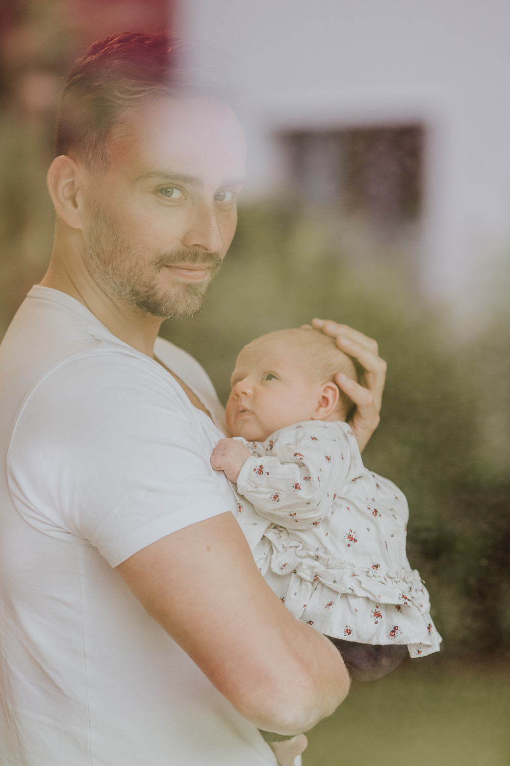 Ein Mann hält ein kleines Baby auf dem Arm.