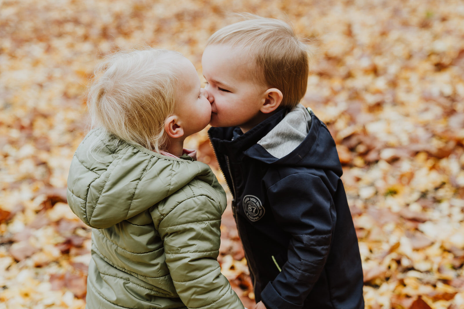 Zwei kleine Kinder geben sich ein Küsschen.