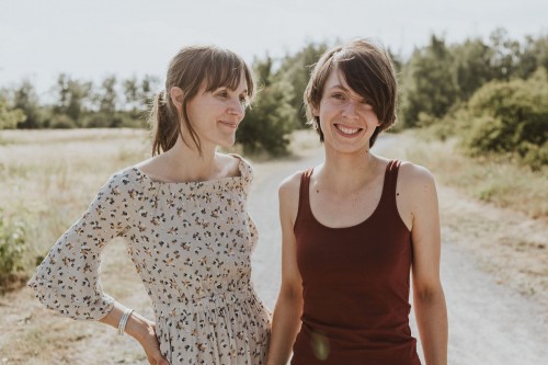 Zwei Frauen stehen auf einem Waldweg.