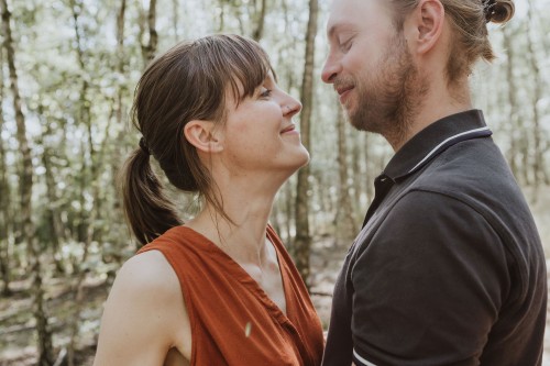 Eine Frau und ein Mann schauen sich an mitten im Wald.