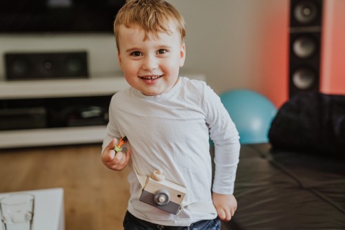 Ein kleiner Junge mit einer Holzkamera.