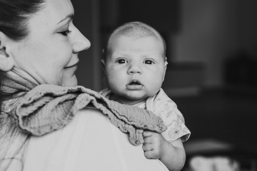 Eine Frau hält ein kleines Baby auf dem Arm.