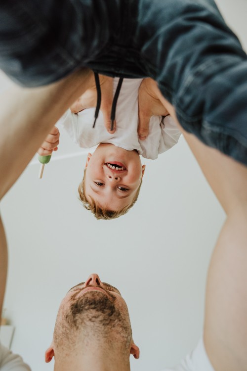 Ein Mann hebt einen kleinen Jungen hoch.