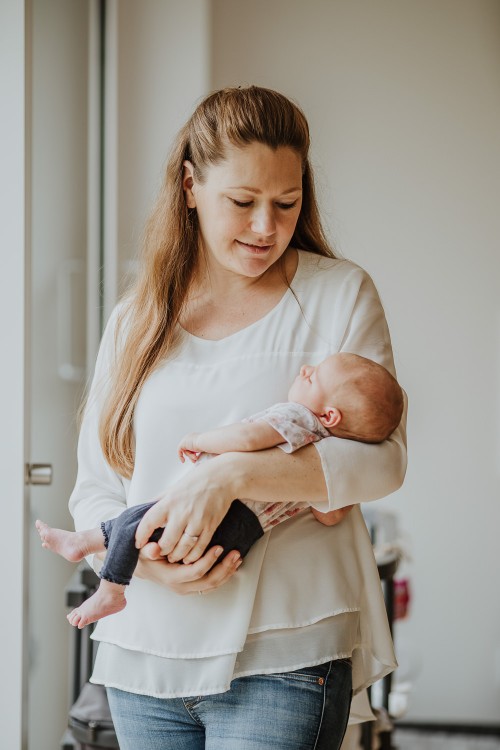 Eine Frau hält ein kleines Baby auf dem Arm.