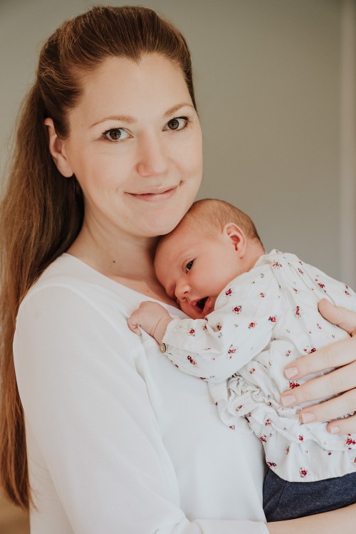 Eine Frau hält ein kleines Baby auf dem Arm.