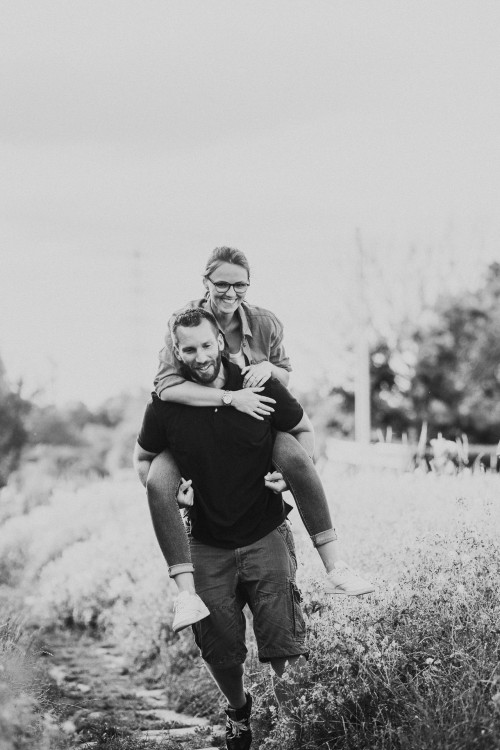 Ein Mann nimmt eine Frau huckepack.