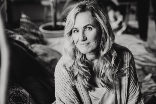 Ein Schwarz-Weiß-Foto einer Frau, die auf einem Bett sitzt