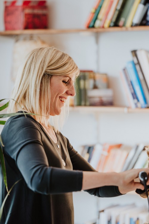 Eine Frau mit Lockenstab in der Hand.