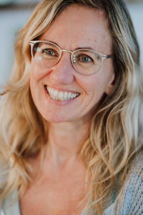 Eine lächelnde Frau mit Brille.