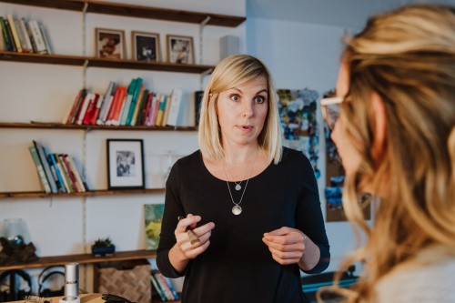 Eine Frau mit einem Makeup Pinsel in der Hand.