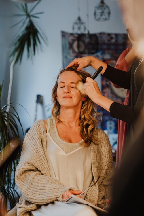 Eine Frau wird von einer Stylistin geschminkt.