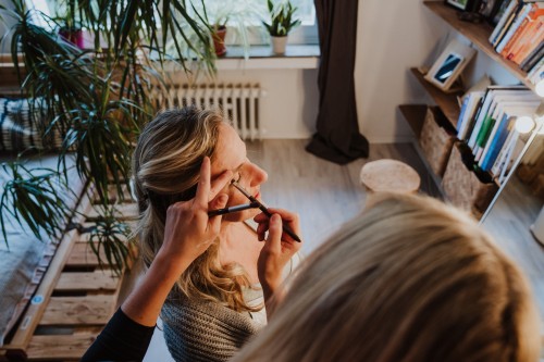 Eine Frau wird von einer Stylistin geschminkt.