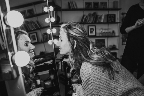 Ein Schwarz-Weiß-Foto einer Frau, die sich im Spiegel betrachtet.