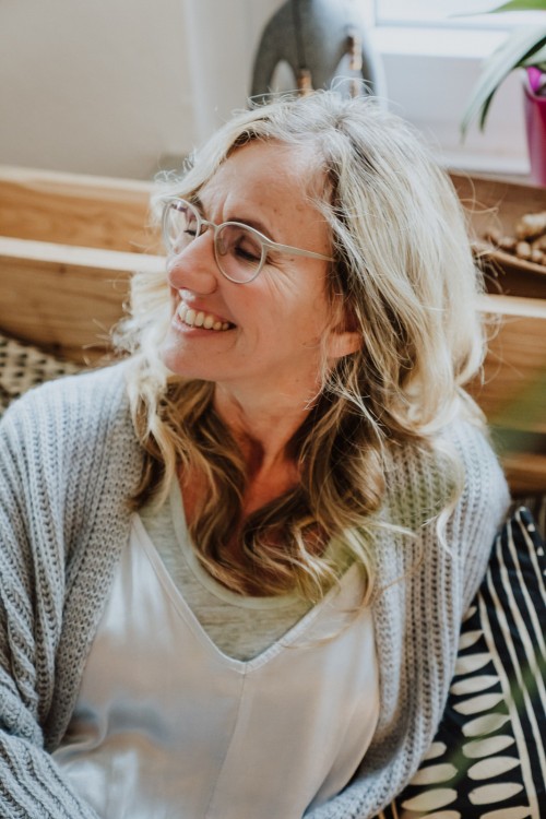 Eine Frau, die auf einem Bett sitzt.