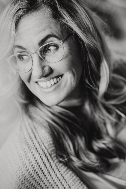 Ein Schwarz-Weiß-Foto einer Frau, die auf einem Bett sitzt