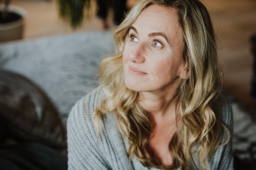 Eine Frau die auf einem Bett sitzt.