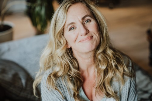 Eine Frau die auf einem Bett sitzt.