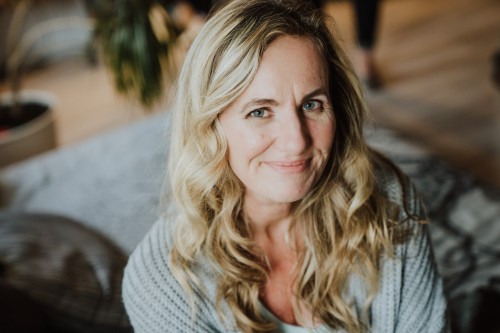 Eine Frau die auf einem Bett sitzt.