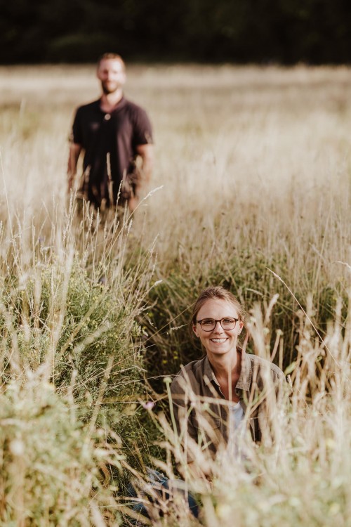Eine Frau sitzt auf einer Wiese.