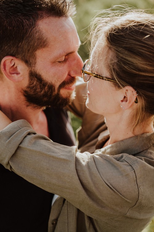 Ein Mann und eine Frau stehen umarmt auf einer Wiese.