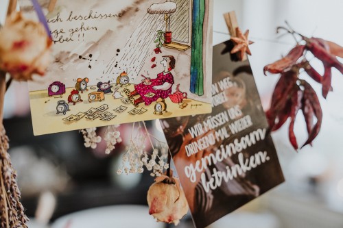 Leine mit Glückwunschkarten und Trockenblumen