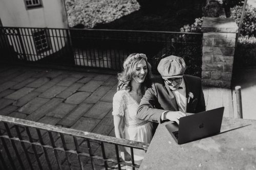Schwarzweißfoto Brautpaar mit Laptop vor dem Standesamt Schloss Borbeck