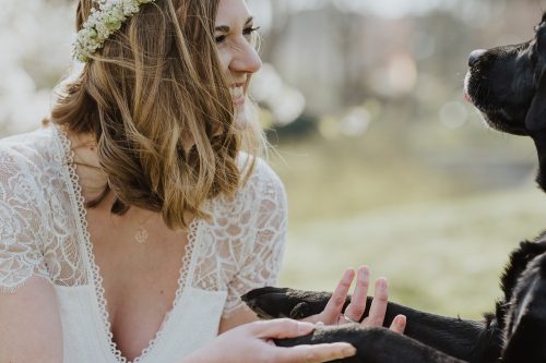 lachende Vintage-Braut mit schwarzem Hund