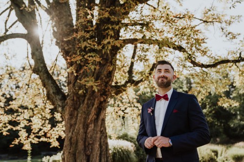 Bräutigam vor Laubbaum im Schloss Park Essen Borbeck