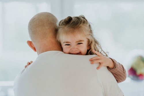 Ein Mann hält ein kleines Mädchen auf dem Arm.