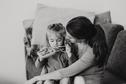 Eine Frau sitzt auf der Couch mit einem kleinen Mädchen.