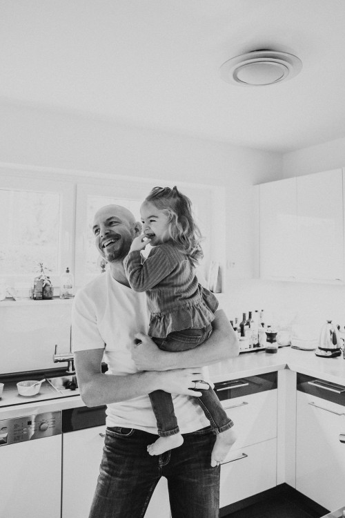 Ein Mann hält ein kleines Mädchen auf dem Arm.