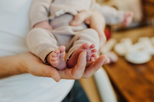 Kleine Baby Füße gehalten in der Hand einer Frau.