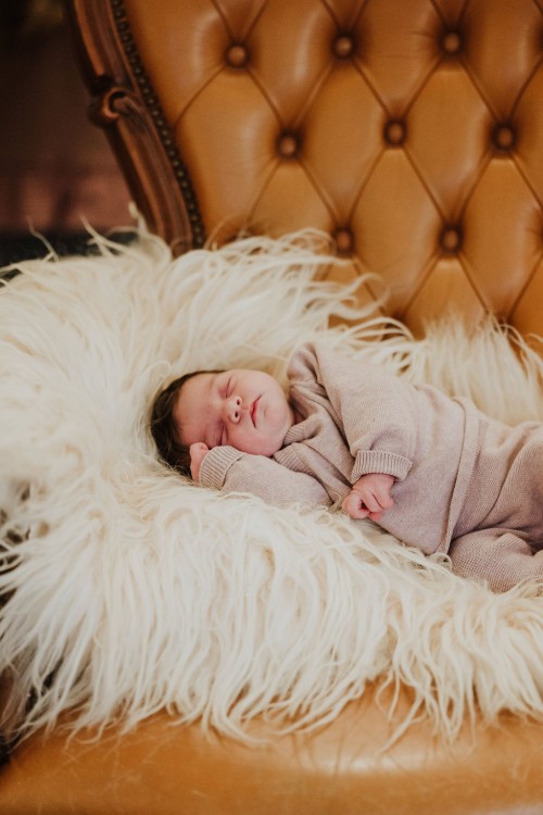 Ein kleines Baby schläft auf einem Fell.