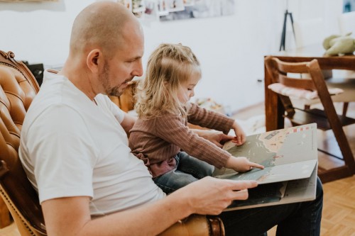 Ein Mann und ein kleines Mädchen lesen ein Kinderbuch.