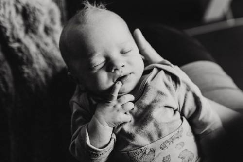 Ein kleines Baby liegt auf den Händen von einer Frau.