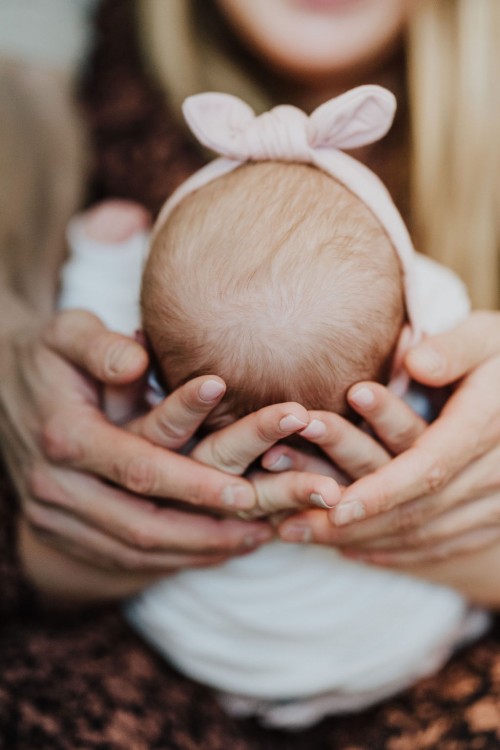 Große Hände halten das kleine Baby.