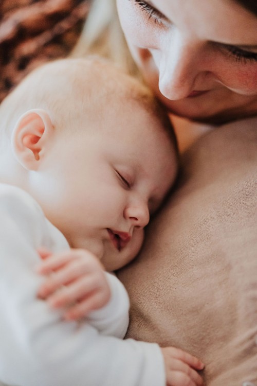 Ein kleines Baby bei einer Frau auf dem Arm.