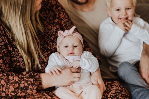 Eine Frau hält ein kleines Baby und ein Mann einen kleinen Jungen.