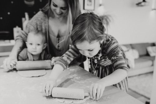 Eine Frau und zwei kleine Mädchen backen Plätzchen.