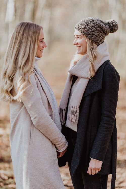 Zwei Frauen stehen im Wald und schauen sich an.