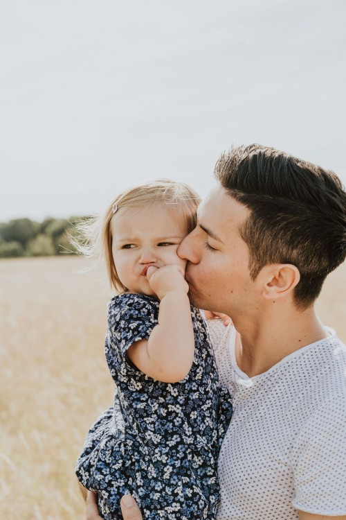 Ein Mann hält ein kleines Mädchen auf dem Arm.