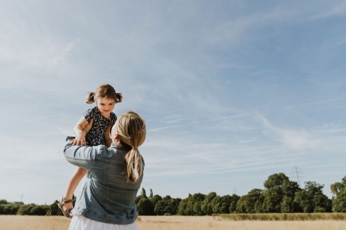 Eine Frau hält ein kleines Mädchen hoch.