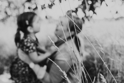 Ein kleines Mädchen und eine Frau sitzen auf einer Wiese.