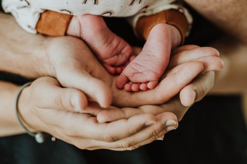 Kleine Baby Füße gehalten von den Eltern.