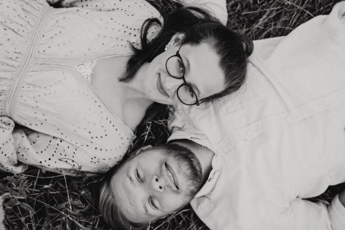 Eine Frau und ein Mann liegen auf einer Wiese.