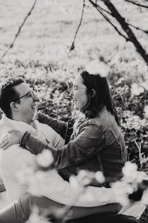 Ein Mann und eine Frau sitzen auf dem Boden und umarmen sich.