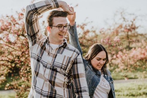 Ein Mann und eine Frau tanzen auf einer Obstwiese.