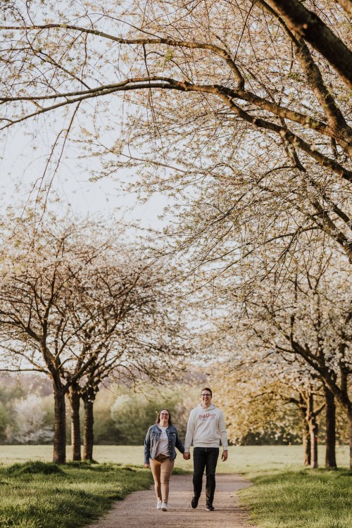 Eine Frau und ein Mann gehen einen Waldweg entlang.