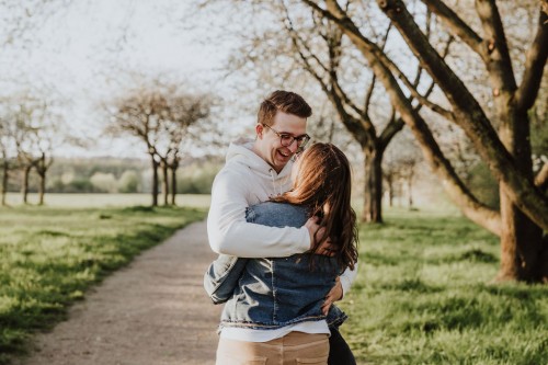 Ein Mann und eine Frau umarmen sich auf einem Feldweg.