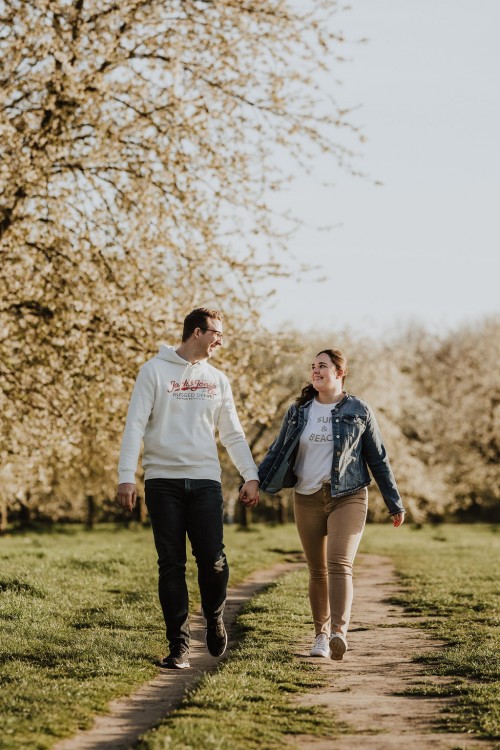 Ein Mann und eine Frau laufen einen Feldweg entlang.